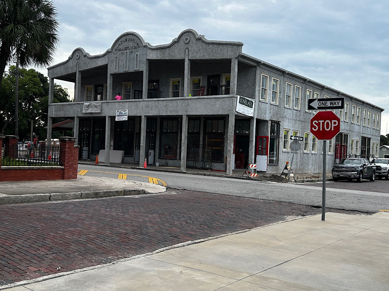 The same corner in October 2026, the building restored in grey with its balconies