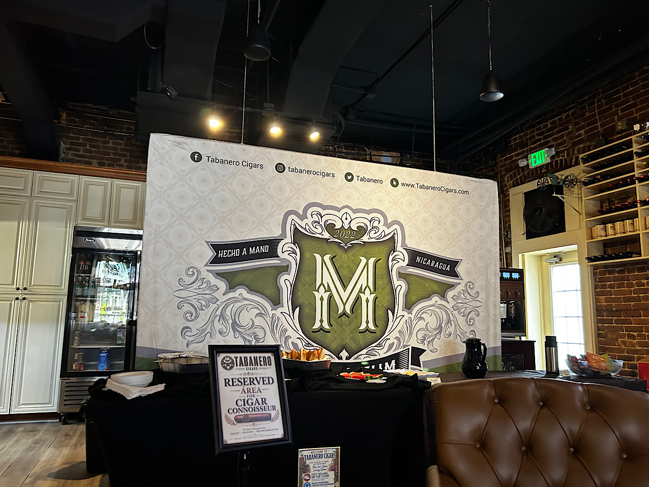 Inside Tabanero Cigars in Ybor: a lounge with a large Maceda M backdrop and a reserved sign